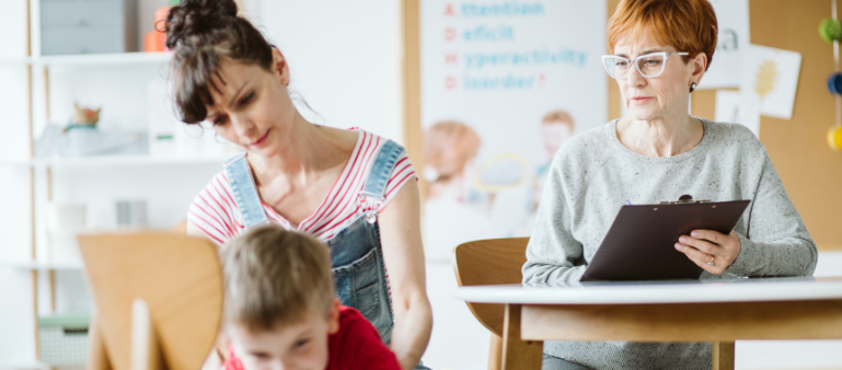a mother assists her son as he is moving in front of her while a person with a clipboard watches (untreated ADHD)